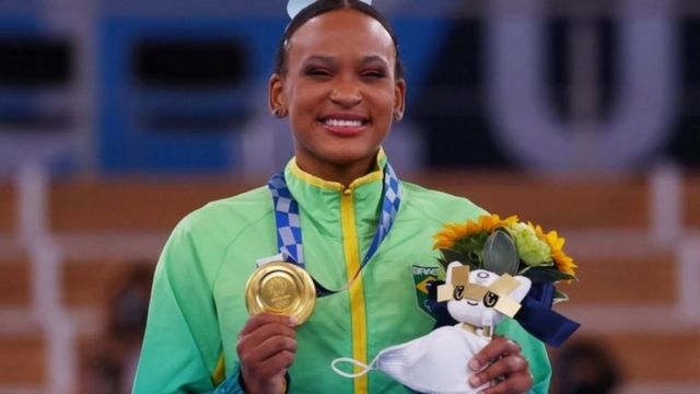 Rebeca posa sorridente com medalha de ouro