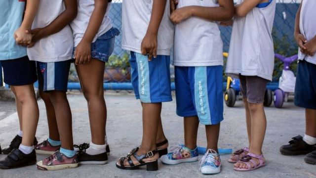 Pernas de crianças vestindo uniforme escolar