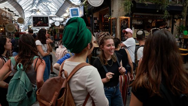 Meninas sem máscaras em um mercado em Jerusalém em abril