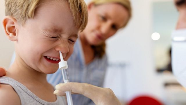 Uma criança recebe uma dose de um medicamento por via intranasal