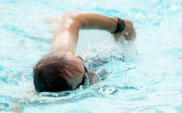 Homem nadando em piscina