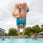 Menino mergulhando de cabeça na piscina