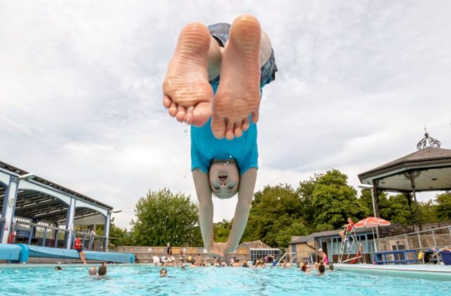 Menino mergulhando de cabeça na piscina